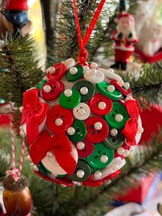 a christmas ornament hanging on a tree with other ornaments in the back ground