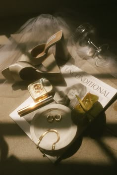 the contents of a purse and shoes are laid out on the floor