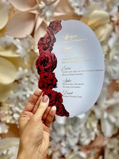 a person holding up a card with roses on it