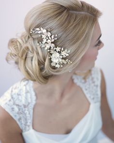 a woman wearing a wedding hair comb with flowers on it