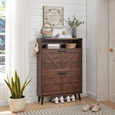 a wooden cabinet sitting next to a potted plant