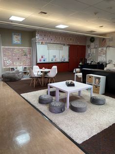 a room with several tables and chairs in it, including two bean bags on the floor