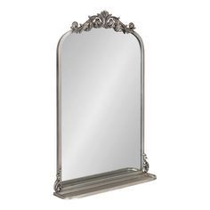 a large silver mirror sitting on top of a shelf