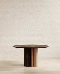 a round wooden table sitting in front of a white brick wall with two different colored bars on it