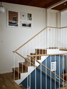 there is a stair case in the house with pictures on the wall and below it