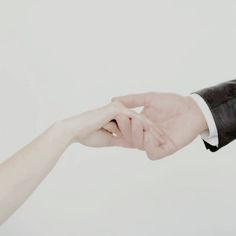 two hands reaching out towards each other in front of a white background with one holding the other's hand