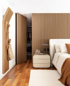 a bedroom with wooden slats on the walls and a white bed in front of it