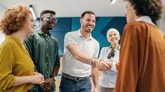 two men shaking hands with three other people