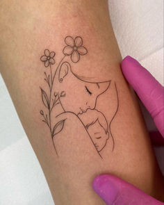 a woman's arm with a tattoo on it and flowers in the corner next to her