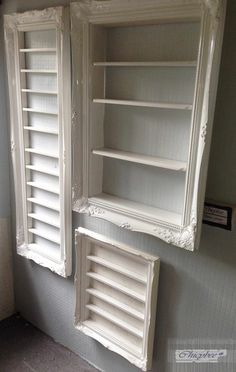 two white painted shelves with shutters on each side and one closed in the middle