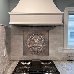 a stove top oven sitting inside of a kitchen next to a wall mounted range hood