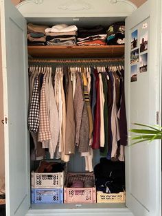 an open closet filled with clothes and boxes