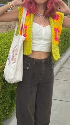 a woman with pink hair is holding a white bag and posing for the camera while standing outside