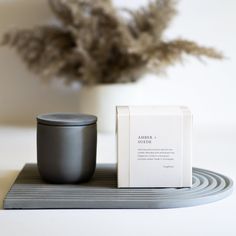 a black candle sitting on top of a table next to a box