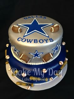 two tiered cake decorated with baseballs, stars and the word cowboys on it