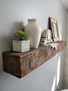 a white vase sitting on top of a wooden shelf