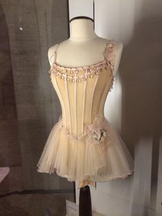 a mannequin with a dress on display in a glass case