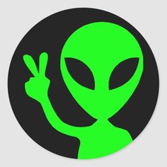 an alien is giving the peace sign in front of a black and green round sticker