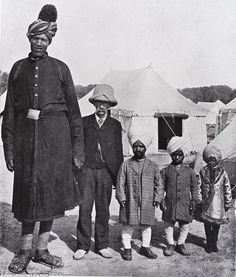 an old black and white photo of people standing in front of tents with one man wearing a turban