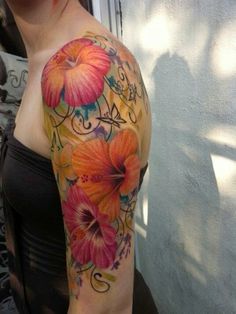 a woman's arm with flowers and swirls painted on the upper half of her arm