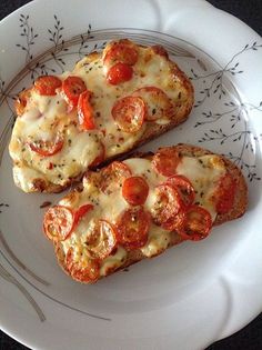 two slices of pizza sitting on top of a white plate