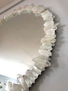 a mirror that is hanging on the wall with some rocks in front of it,