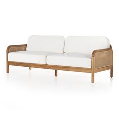 a wooden couch with white cushions sitting on top of it's backrests