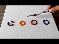 someone is using scissors to cut out small rings on the paper and glue them together