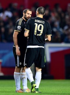 two soccer players are talking on the field