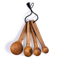 four wooden spoons are hanging from a string