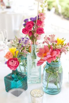 three vases filled with colorful flowers on top of a table