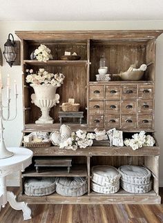 an old wooden cabinet filled with lots of white flowers and other things on top of it