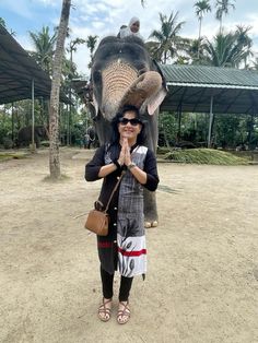 a woman standing in front of an elephant