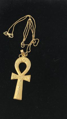 an egyptian cross pendant on a gold chain