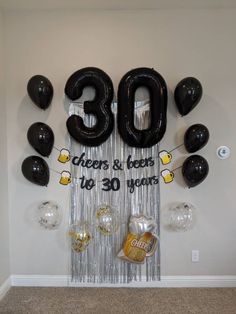 balloons and streamers are hanging from the wall in front of an 30th birthday banner