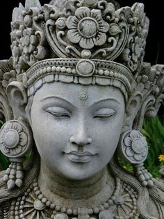 a close up of a statue of a woman with flowers in her hair and eyes closed