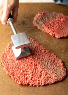 a person using a meat slicer to cut up hamburger patties