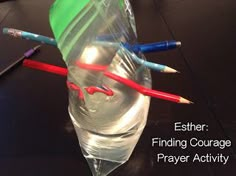 two pencils are sticking out of a plastic cup with water in it and the words estther finding courage prayer activity