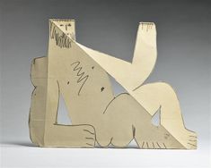 a sculpture made out of cardboard with writing on it's back and legs, sitting in front of a gray background