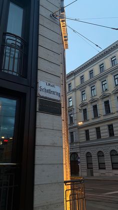 a street sign on the side of a building in an urban area with buildings behind it