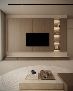 a living room with a large tv mounted to the wall and books on the coffee table