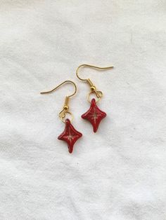 Red diamond star / sparkle charms with red and gold glitter.  Everything is sculpted and painted by hand - no moulds or cutters are used. I only produce one set of each design, so every pair really is one of a kind. You'll never run into someone else wearing the same earrings! Packaged with hand drawn card and muslin bag, perfect for gifting. All postal packaging is reused / recycled where possible.  Nickel free hooks are comfortable to wear. Rubber stoppers are included for security. If you hav Clay Charm Earrings, Diamond Star Earrings, Hand Drawn Cards, Glitter Earrings, Earrings Christmas, Red Diamond, Earrings Polymer Clay, Diamond Star