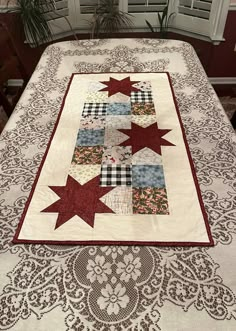 a quilted table runner with red stars on it