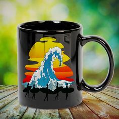 a black coffee mug with an image of a wave on the front and bottom, sitting on top of a wooden table