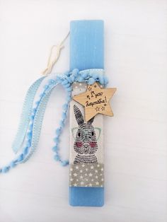 a blue candle with a wooden star hanging from it's side