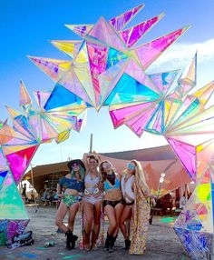 three women standing under colorful umbrellas at an outdoor event