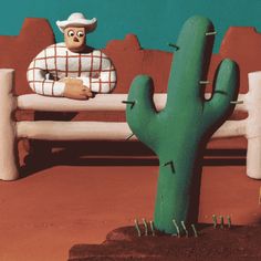 a cactus sitting on top of a bench next to a green cactus