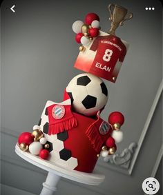 a soccer themed cake with a trophy on top and balls all over the cake, as well as decorations