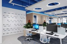 an office cubicle with multiple computer screens and desks on each side of the room