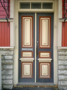 the front door is painted red and blue with white trimmings on each side